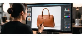 Professional Photoshop artist retouching leather handbag on graphics display